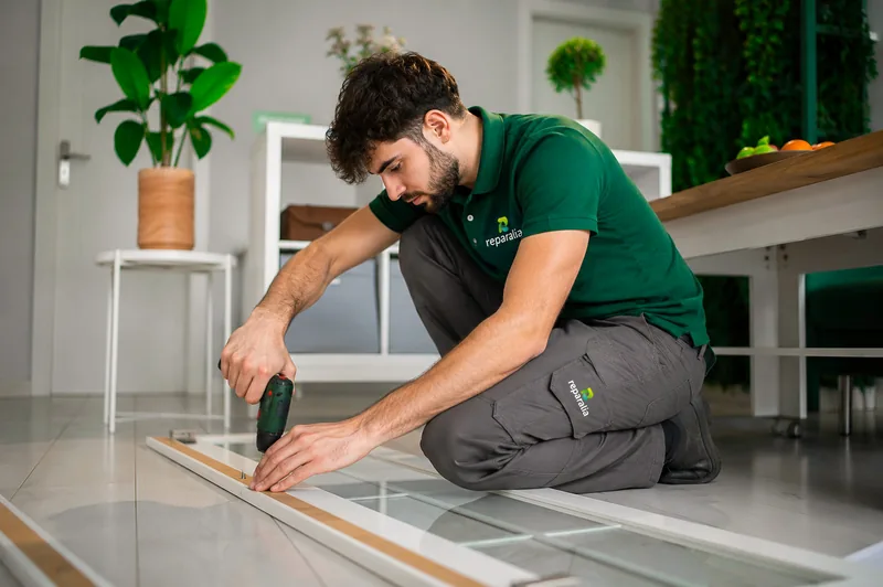 Carpintero de Reparalia atornillando un listón de madera en el suelo de una vivienda
