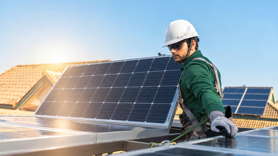 Técnico de Reparalia con casco colocando un panel solar en un tejado